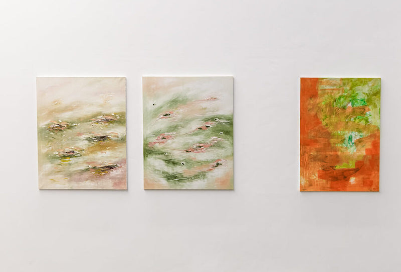 Three abstract paintings on a white wall at The Edit